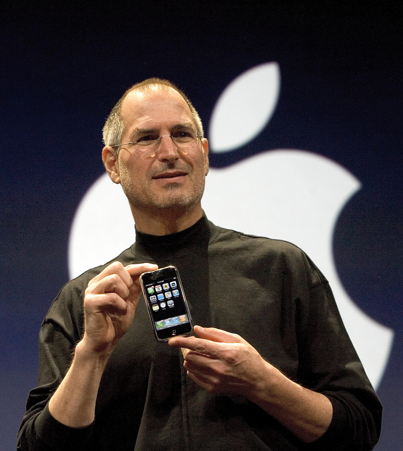 Steve Jobs na odru s prvim iPhonom v rokah.